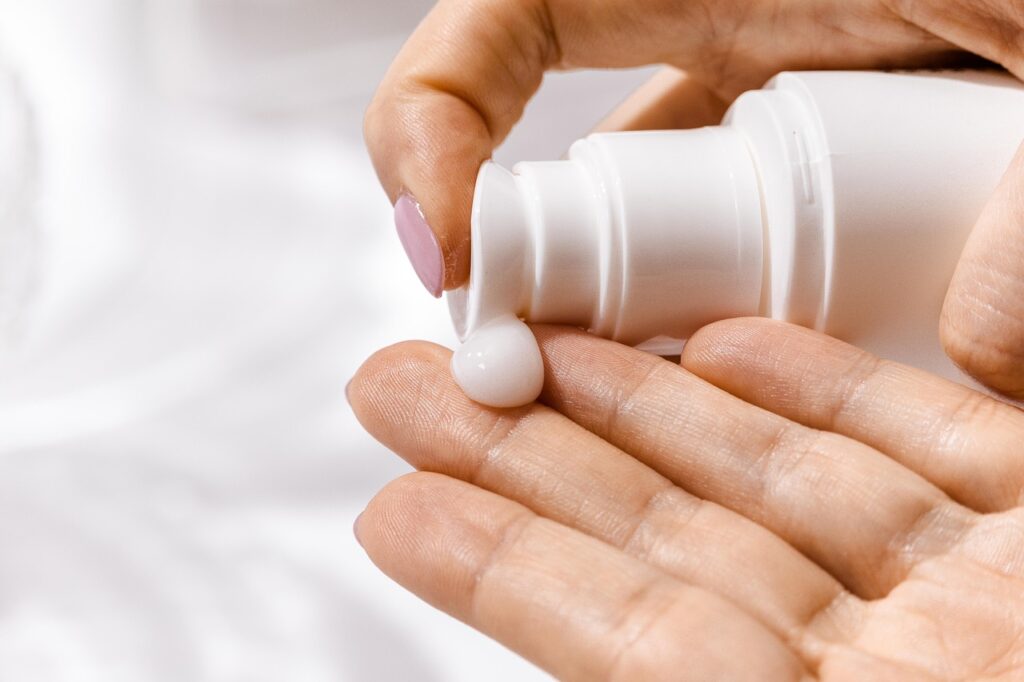 Personne qui se met un produit de beauté sur la main
